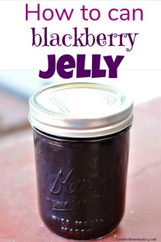 a jar filled with jelly sitting on top of a pink counter next to the words how to can blackberry jelly