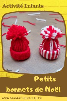 two red and white knitted hats sitting on top of a wooden table next to a brick wall