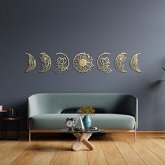 a living room with a couch and coffee table in front of the moon phases on the wall