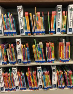 there are many books on the shelves in this store that is filled with different colored pencils