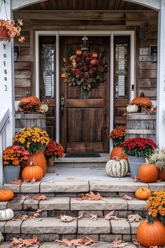 the front door is decorated with pumpkins and flowers