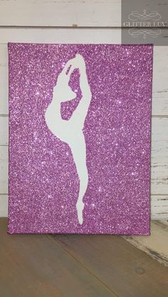 a purple glittered canvas with a white silhouette of a ballerina dancer on it