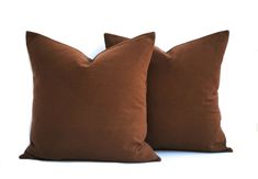 two brown pillows sitting next to each other