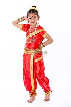 a young boy dressed in red and gold poses for the camera with his hands on his head