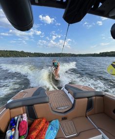 a person on a motorboat being pulled by a boat in the water with other boats behind them