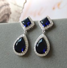 Vintage style zircon  earrings  Great for you or for your bridesmaids. Colour: rhodium/silver tone/clear/blue Stud earrings. Measurements: approx 3.5 cm, width approx  x 12mm . Materials:  rhodium over brass  components, zircon crystals. SAME STYLE in silver tone: https://www.etsy.com/uk/listing/962646758/wedding-earrings-for-brides-art-deco?ref=shop_home_active_2 SAME STYLE in rose gold/clear tone: https://www.etsy.com/uk/listing/962643498/rose-gold-wedding-earrings-for-brides?ref=shop_home_act Sapphire Art Deco Jewelry For Wedding, Sapphire Art Deco Wedding Jewelry, Sapphire Dangle Crystal Earrings For Formal Occasions, Sapphire Crystal Dangle Earrings For Formal Events, Sapphire Crystal Dangle Earrings For Formal Occasions, Blue Art Deco Wedding Earrings, Elegant Blue Crystal Wedding Earrings, Elegant Blue Crystal Earrings For Wedding, Elegant Sapphire Bridal Earrings For Party