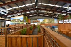 the inside of a building with wooden benches and plants on either side of the walkway