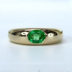 Make a bold statement with this stunning Dome Statement Ring featuring a bezel-set oval cut natural Colombian Emerald. The rich green hue of the emerald, weighing 0.61 carats, captures attention from every angle. Crafted with exquisite detail, the emerald is set east to west, adding a unique and contemporary touch to the design. SPECIFICATIONS: 1982651 Central stone: One oval cut natural Colombian Emerald. Weight: 0.61 carats. Material: 14K yellow gold. Total Weight: 6.1 grams. Ring Size: 6 or L Fine Jewelry Emerald Green Oval Cabochon Ring, Green Oval Cabochon Emerald Ring, Green Emerald Ring With Oval Cabochon Bezel Setting, Oval Emerald Ring With Bezel Setting, Classic Oval Cabochon Emerald Ring, Classic Green Emerald Oval Cabochon Ring, Classic Green Oval Cabochon Emerald Ring, Formal Oval Cabochon Emerald Ring For May, Classic Green Rings With Bezel Setting