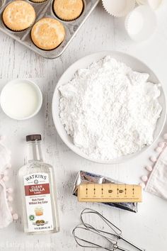 the ingredients to make cupcakes are laid out on a white table with baking utensils