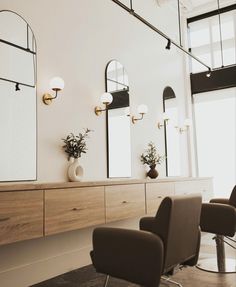 a hair salon with chairs and mirrors on the wall