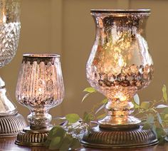 three glass vases sitting on top of a wooden table