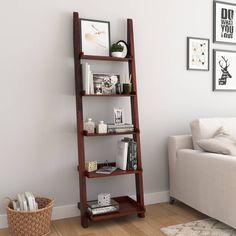 a living room with a white couch and wooden ladder bookshelf in the corner