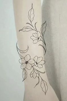 a woman's arm with flowers and leaves drawn on the back of her leg