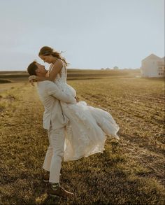 a bride and groom kissing in the middle of an open field on their wedding day