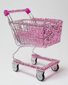 a shopping cart with pink sequins on the front and back wheels is shown