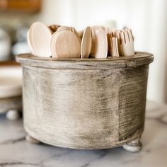 wooden utensils in a metal container on a marble table