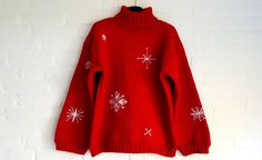 a red sweater with white snowflakes hanging on a brick wall