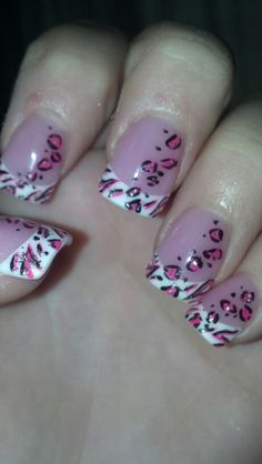 a person with pink and black leopard print on their nails