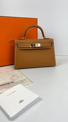 A sophisticated Brown Epsom leather Hermes Kelly bag with coveted gold hardware.Comes with Hermes signature orange box, shoulder strap and sleeper.d  Hermes Kelly 20 Mini bag in classic black.NEW or NOT WEARABLEThe price of the Hermes Kelly 20cm retains its value due to the high demand for this limited style.Last Sale BAG MEASURES:LENGTH 20cm / 8 7/8"TALL 12cm / 4 3/4"DEEP 6cm / 2 3/8" Hermes Collection, Galaxy Stuff, Kelly Bags, Orange Box, Hermes Kelly Bag, Orange Boxes, Kelly Bag, Hermes Bags, Hermes Bag