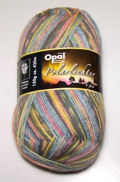 a ball of yarn with multicolored stripes on the top and bottom, sitting on a white surface