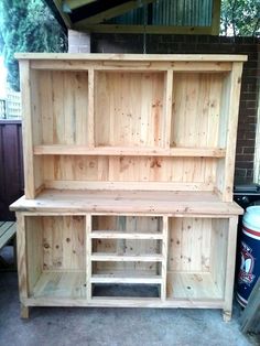 a large wooden shelf sitting next to a trash can