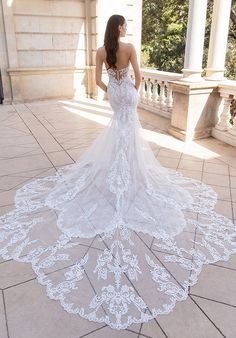 a woman in a white wedding dress standing on the ground with her back to the camera