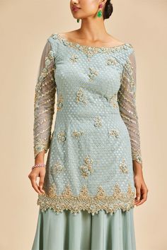 Editor's Note Dusty blue shimmer georgette sharara with georgette kurta embroidered in light gold and self resham, zari and beadwork with net dupatta Color: Blue Fabric: Georgette and net Components: Sharara, dupatta and kurta Occasion: Wedding guest Disclaimer: Product color may slightly vary due to photographic lighting sources or your monitor setting. Care: Dry Clean Only About the Designer Nitika Gujral’s journey with designing clothes started almost four decades back while she was still in Blue Sharara, Kurta And Sharara, Georgette Sharara, Georgette Kurta, Designing Clothes, Blouse Yoke, Blue Kurta, Sharara Set, Net Dupatta