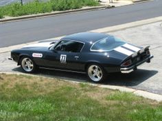 an old muscle car parked on the side of the road