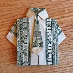 an origami shirt and tie made out of dollar bills on a wooden table