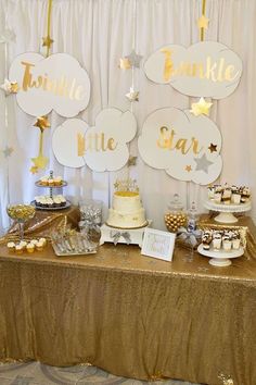 a table topped with cake and cupcakes covered in gold foil next to a sign that says twinkle little star baby