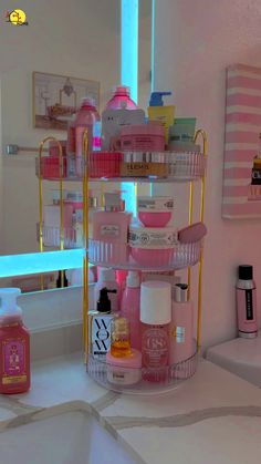 a bathroom with pink and gold accessories on the counter