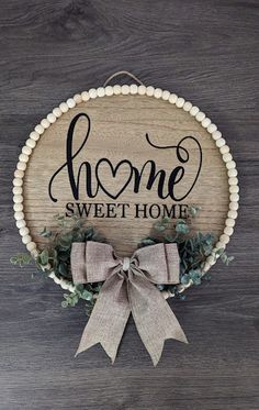 a wooden sign that says home sweet home with a bow on the front and side