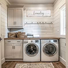 a washer and dryer in a white laundry room with wood flooring on the walls