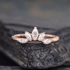 a rose cut diamond ring sitting on top of a rock