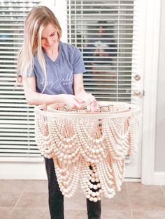 a woman standing in front of a table with beads on it