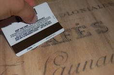 a person is stamping out some type of business card on a piece of wood