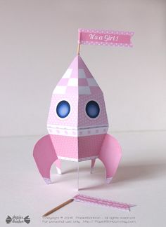 an origami rocket ship with a pink flag on top