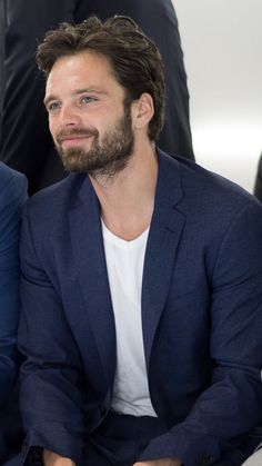 a man sitting next to another man in a suit