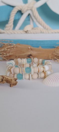 TitiTataStore.etsy.com Always FREE SHIPPING and a FREE GIFT! I Will Ship Within 24 Hours. Description:  A Set of 2 Beachy Style Handmade Bracelets.  Materials: 8mm Beige Faceted Jade Beads, 8mm Frosted Blue Cultured Sea Glass Beads, 8mm Matte Fossil Coral Riverstone Beads, 8mm Ivory Matte Jasper Beads, 8mm Wood Beads and, Natural Shell Beads, and 8mm Rondelle Lava Rock Beads.  Every bracelet is handmade using a high-quality elastic stretch cord for durability. Size: Each bracelet is suitable for Coastal Bracelet, Beachy Bracelets, Glass Bracelets, Seashell Beach, Seashell Bracelet, Burlap Gift Bags, Gold Bracelet Simple, Sea Glass Beads, Ocean Style