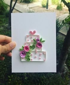 a hand holding up a card with flowers on it