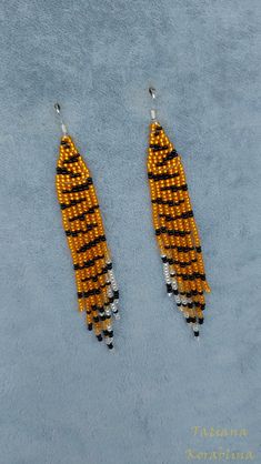 two yellow and black seed shaped earrings