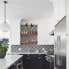 a kitchen with black and white tile backsplash