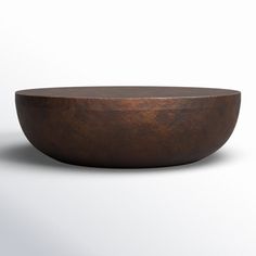 a wooden bowl sitting on top of a white table