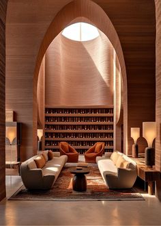 a living room filled with lots of furniture next to a wine rack on the wall