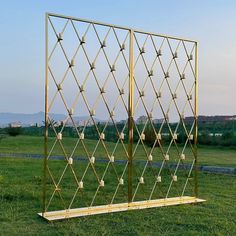 a large metal structure sitting on top of a lush green field