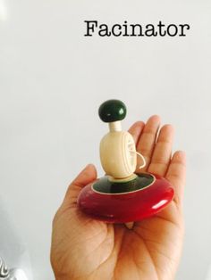 a hand holding a miniature figurine with the word faciator above it