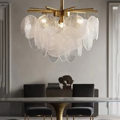 a modern chandelier hanging over a dining room table