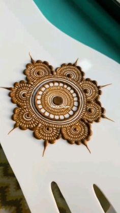 an intricate design on the side of a white table top with two forks next to it