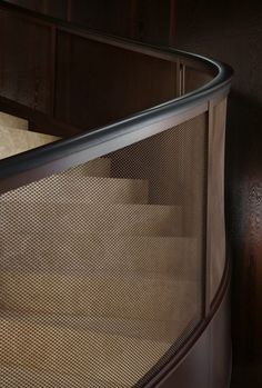 a close up view of a metal railing on a wooden stair case with wood paneling