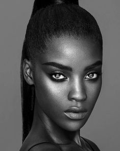 a black and white photo of a woman's face with her hair in a ponytail